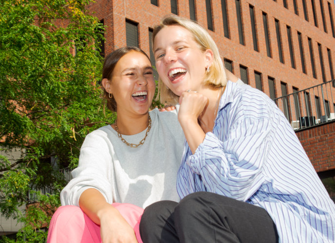 Stimmungsbild: 2 Studierende vor Unigebäude