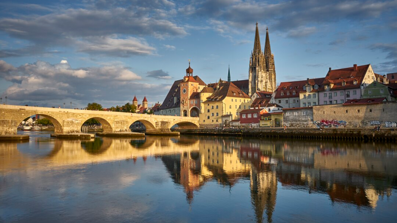 Historische Steinbrücke über die Donau in Regensburg mit Blick auf die Altstadt und den Regensburger Dom.