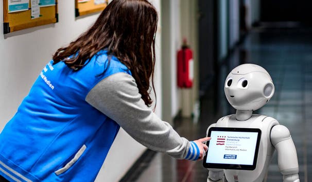 Studentin der Medizininformatik mit Assistenz-Roboter "Charles"